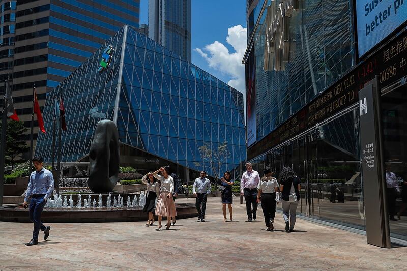 有舆论认为,特朗普反制中国的措施,反而令香港国际金融中心的地位更加重要。图为2019年8月5日,办公室工作人员走过一个电子板,显示5日香港金融区的股票价格。(美联社)